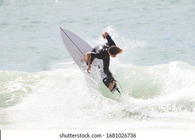 MANLY, NSW/AUSTRALIA – MARCH 2020: Young Adults Catching Waves Surfing At Manly Beach On A Bright Warm Sunny Day On Clear Blue Water