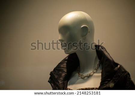 Mannequin of bald girl. White head made of plastic. Mannequin on white background. Figure of man. Window of clothing store.