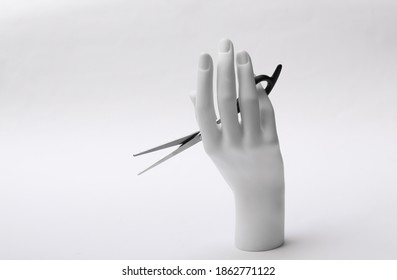 Mannequin Hand Holding Hair Scissors On White Background. Minimalism Beauty Concept