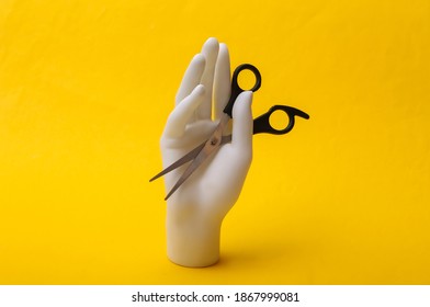 Mannequin Hand Holding Hair Scissors On Yellow Background. Minimalism Beauty Concept