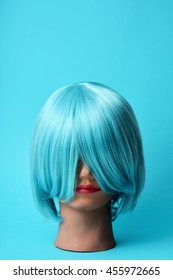 A Mannequin Head With A Blue Hair Wig On A Blue Background