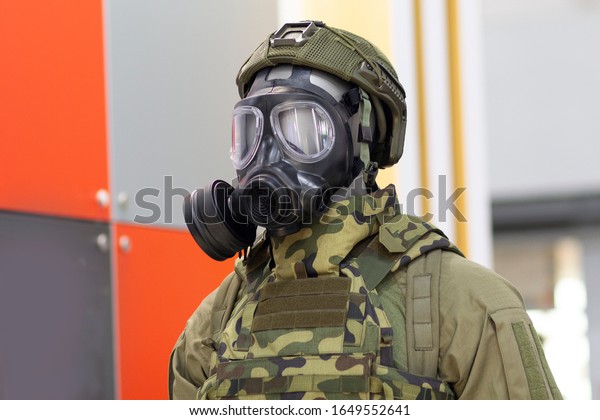 Mannequin head in gas mask and\
chemical protective suit made of special fabric in marking\
green