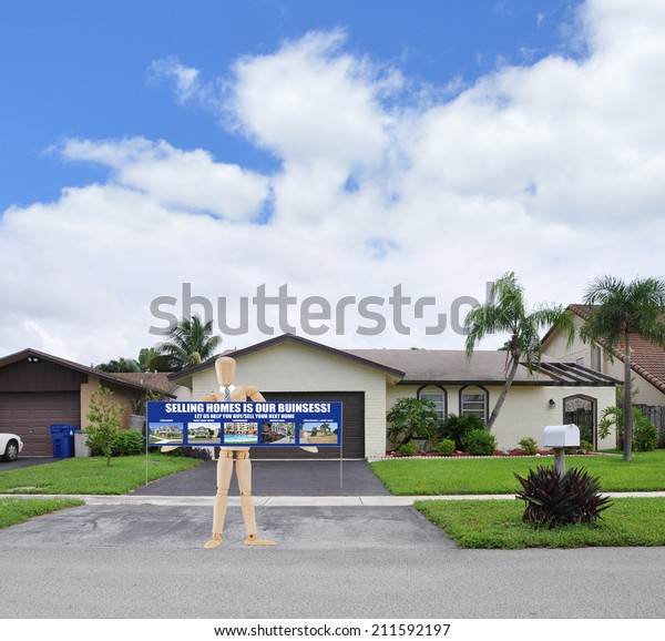 Mannequin holding real estate sign standing in\
blacktop driveway suburban ranch home landscaped residential\
neighborhood blue sky\
clouds