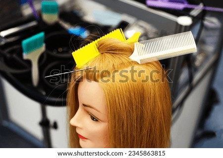 Mannequin with long hair for the exercise of young hairdressers. The process of teaching women's hairstyles in the classroom. selective focus