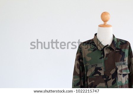 A mannequin wearing Vintage military  Camouflage jacket in a camo print with a US Army patch on the chest