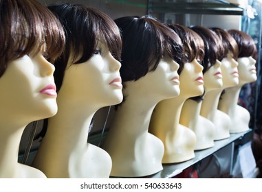 Mannequins With Brown-haired And Brunet Style Wigs On Shelves Of Hair Salon