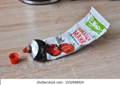 Mannheim,Germany-10.16.2019:Closeup Of Open 200 Grams Certified Organic Tomato Paste, Double Concentrated  In Tube On Top Of Wooden Kitchen Counter