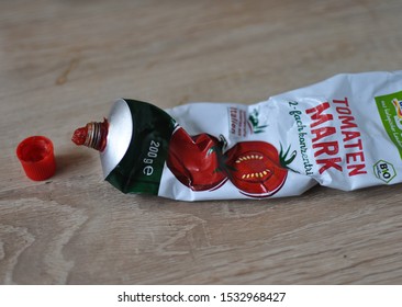 Mannheim,Germany-10.16.2019:Closeup Of Open 200 Grams Certified Organic Tomato Paste, Double Concentrated  In Tube On Top Of Wooden Kitchen Counter