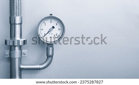 Manometer for measuring pressure on a blue metal background with free space for text, industrial concept background