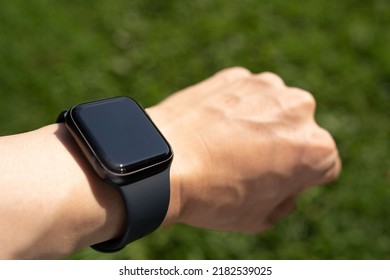 Man's Arm With A Smartwatch In The Park.