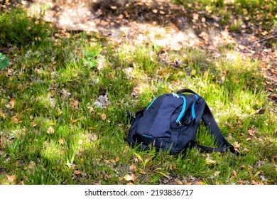 The Man's Backpack Lies On The Grass In The Forest. Missing Person Concept. An Accident In The Forest. Lost Mushroom Picker. Attack Of A Wild Animal. Fatal Outcome.