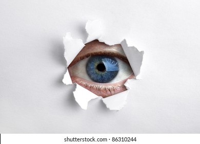 Mans Eye Peeking Through A Hole In White Paper