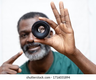 A Man's Eye Viewed Through A Close Up Of A Camera Lense.