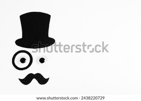 Man's face made of fake mustache, hat, eyes and monocle on white background, top view. Space for text