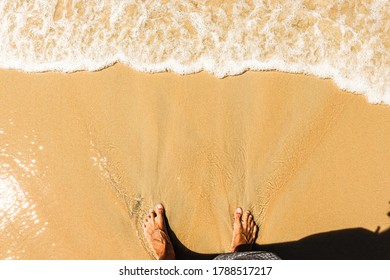 Mans feet in clear water on beach / Pé na água do mar