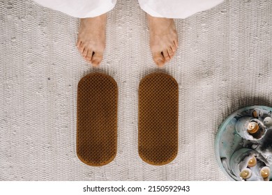 The man's feet are next to boards with nails. Yoga classes.