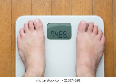 Man's feet on weighting scale