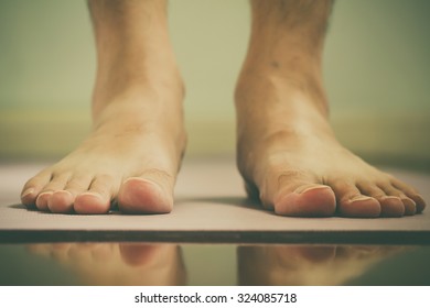 Man's Feet On Yoga Mat Before Exercise With Reflex On Floor