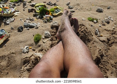 Man's Feet Sunbathing On White Sand On The Beach.