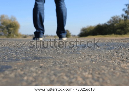 mans feet walking along the road