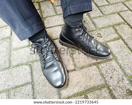 Man's feet wearing the black pantoffle shoes