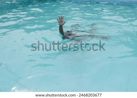 a man's hand asks for help drowning in a swimming pool (someone is drowning in a swimming pool)
