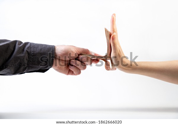 A man\'s hand in a black\
shirt gives a stack of money to a woman\'s hand, which refuses. Side\
view. White background. The concept of the world anti-corruption\
day