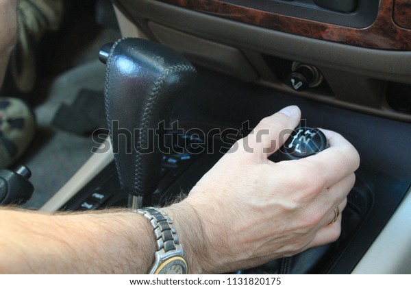 Man\'s hand changing gear symbolizing car safety\
and driving etiquette