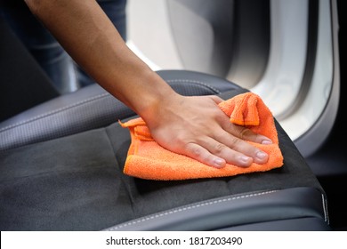 Man's Hand Cleaning Car Interior In Luxury Car With Microfiber Cloth. Hand Wipe Down Suede Leather Seat Of Sports Sedan.  Interior Car Detail & Leather Seat Repair Background. Car Wash & Clean Concept