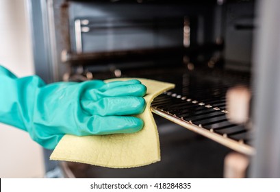 Man's hand cleaning the kitchen oven