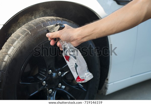 man\'s hand is cleaning\
tire and waxing 