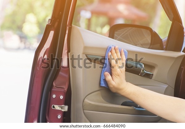 Man\'s hand is\
cleaning and waxing the\
car