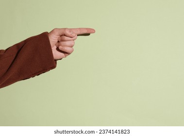 Man's hand in coat points his finger at an empty space for your text. - Powered by Shutterstock