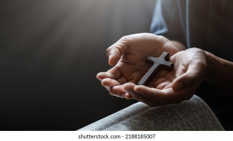 Man's Hand With A Cross On An Open Bible Concept Of Hope, Faith, Christianity, Religion, Church, Belief, Forgiveness