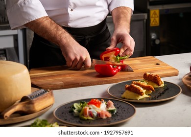 man's hand cuts ripe red peppers in restaurant kitchen. Cutting Bell Pepper indoors. Cooking fresh, ripe, bell pepper salad for guests. Summer fresh vegetable salad. close-up - Powered by Shutterstock