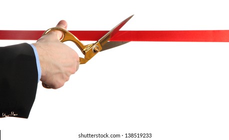 Man's hand cutting red ribbon with pair of scissors isolated on white