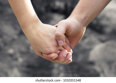 Man's hand firmly holding the female against the background of the stream, concept of love and Valentine's day