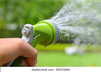 Man's Hand With Garden Hose Watering Plants