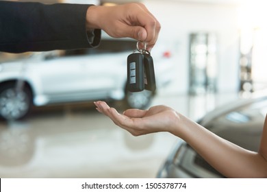 Man's Hand Giving Car Keys To A Woman Closeup