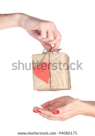 Man's hand giving parcel with blank heart-shaped label to woman isolated on white