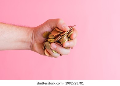 man's hand grabbing a pile of euro cent coins. changeover concept. greed