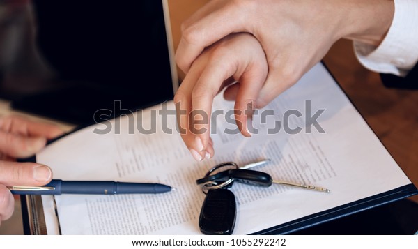 Man\'s hand grabs woman\'s hand, which tries to\
take car keys from table. Concept of property section under\
divorce. Property division\
concept.
