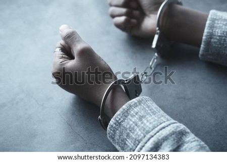 man's hand with handcuff on black background.