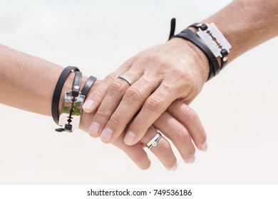 The man's hand hold the woman's hand. Close up hands with beautiful engagement rings. Style wedding. Fashionable couple. Hands with bracelets and blades.  - Shutterstock ID 749536186