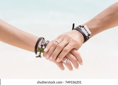 The man's hand hold the woman's hand. Close up hands with beautiful engagement rings. Style wedding. Fashionable couple. Hands with bracelets and blades.  - Shutterstock ID 749536201