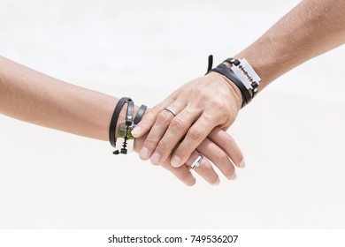 The man's hand hold the woman's hand. Close up hands with beautiful engagement rings. Style wedding. Fashionable couple. Hands with bracelets and blades.  - Shutterstock ID 749536207