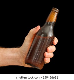 Man's Hand Holding A Brown Bottle Of Beer Isolated On Black