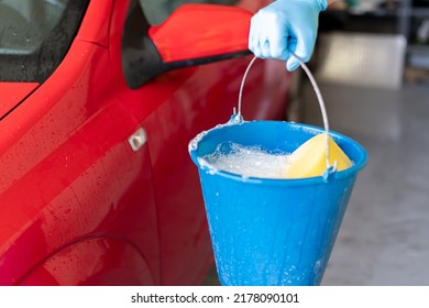 Man's Hand Holding A Bucket With Soap To Wash His Car