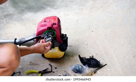 Man's Hand Is Holding Carburetor Mower Machine Repair.