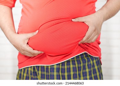 man's hand holding excessive belly fat, overweight concept - Shutterstock ID 2144468063